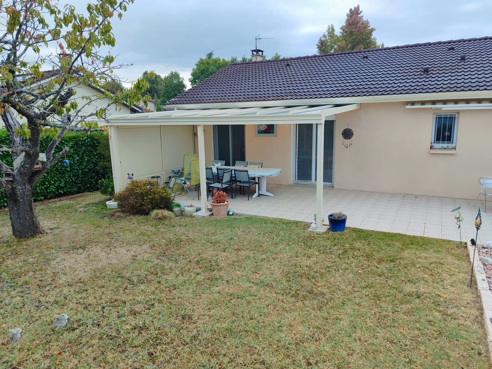 Pergola blanche adossée à une maison, au-dessus de la terrasse