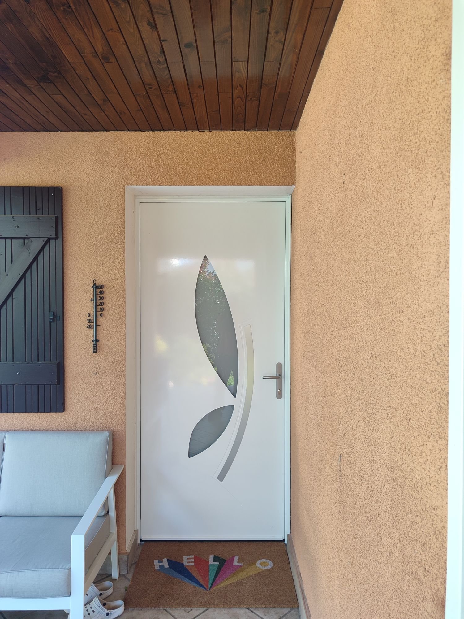 Porte d'entrée blanche à vitrage en forme de feuille