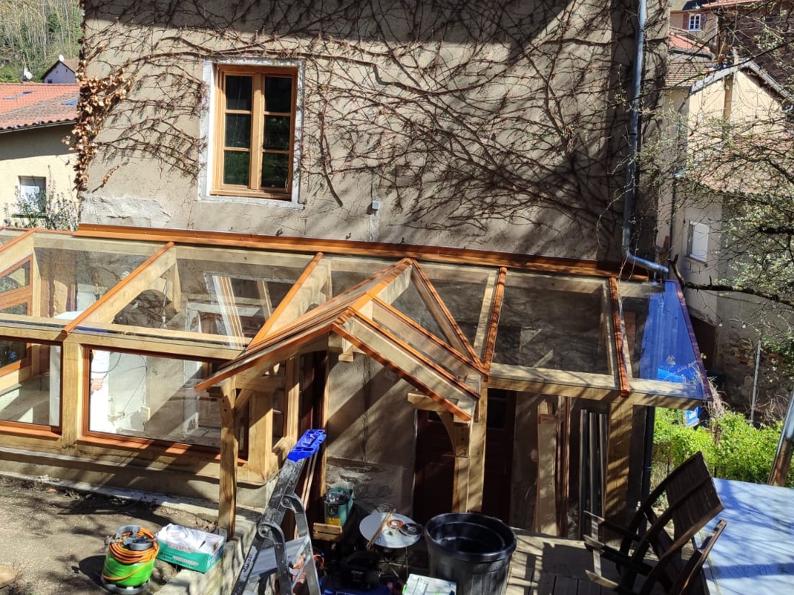 Après : sas d'entrée vitré à ossature bois contre une maison en pierre